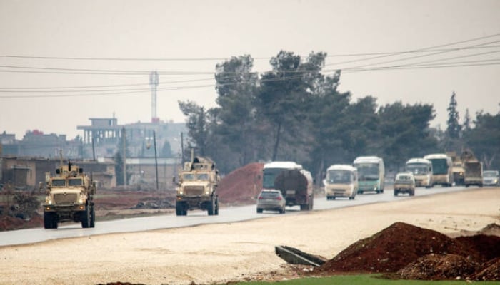 US military vehicles move along a road in a convoy transporting Daesh group detainees being transferred to Iraq from Syria, on the outskirts of Qahtaniyah in Syrias northeastern Hasakah province on February 7, 2026. —AFP
