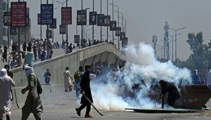 PTI activists and supporters of former prime minister Imran Khan, clash with police during a protest against the arrest of their leader in Peshawar on May 10, 2023. — AFP