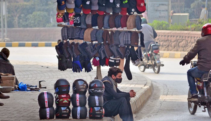 A street vendor waits for customers along the roadside to sell his stuff and earn daily wages for the livelihood of his family in Rawalpindi on January 13, 2026. — Online