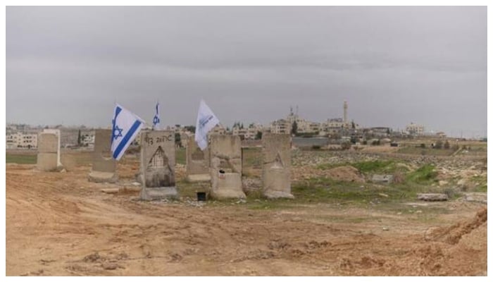 A photograph shows Israeli flags and a Gush Etzion council flag at the newly built Israeli settler outpost of “Yatziv” on the outskirts of the Palestinian town of Beit Sahur in the Israeli-occupied West Bank. — AFP/File