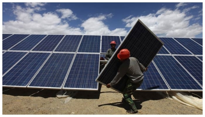 This image shows workers installing a solar panel in Jiuquan, Gansu province. — Reuters/File