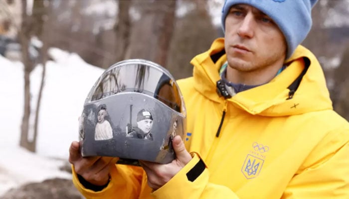 Ukrainian skeleton racer Vladyslav Heraskevych holds his helmet, which depicts victims of his countrys war with Russia. — AFP/File