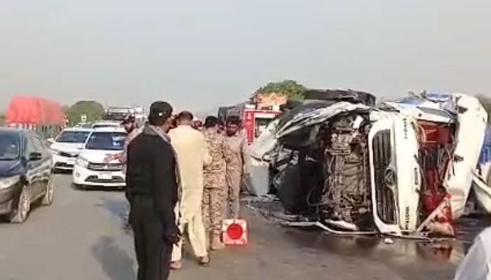 An oil tanker lies overturned after the accident on the M-9 motorway as rescue personnel and law enforcement officials inspect the scene on February 13, 2025. — The News/Zeeshan Shah