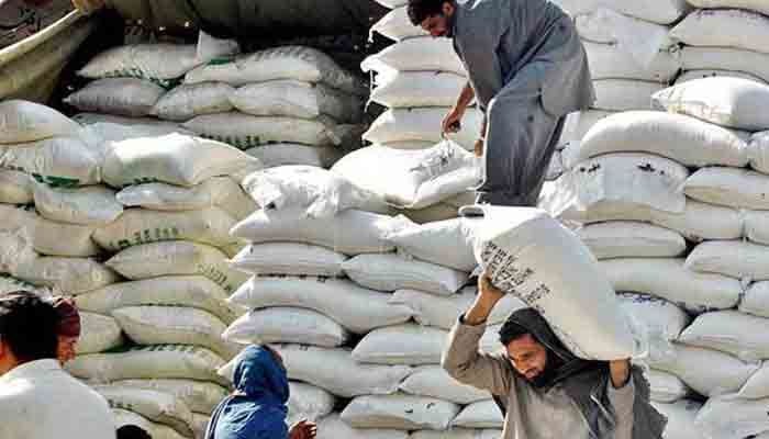 Labourers are seen shifting the sacks of flour. — The News/File