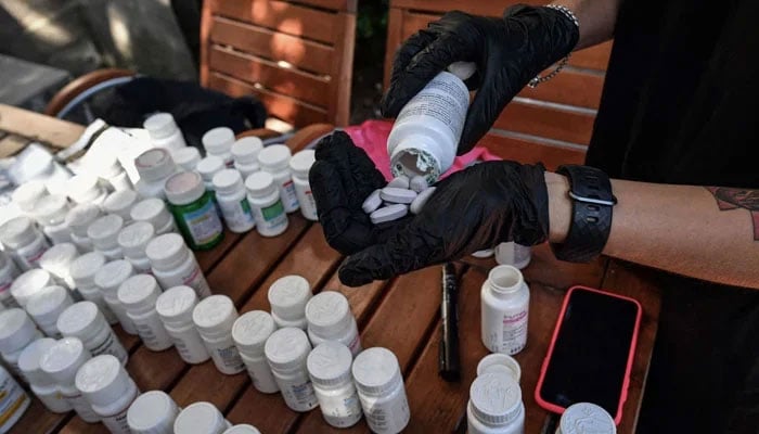 A nurse sorts anti-HIV medication pills for patients. — AFP/File