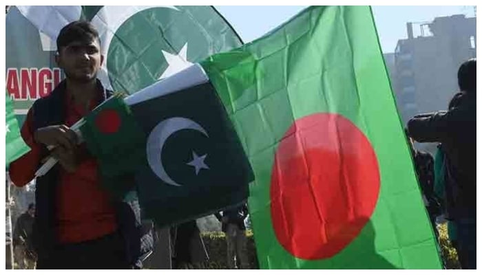 A man holding flags of Pakistan and Bangladesh. — APP/File