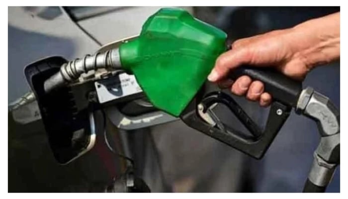 A representational image of a man holding a fuel nozzle at a petrol station. — AFP/File