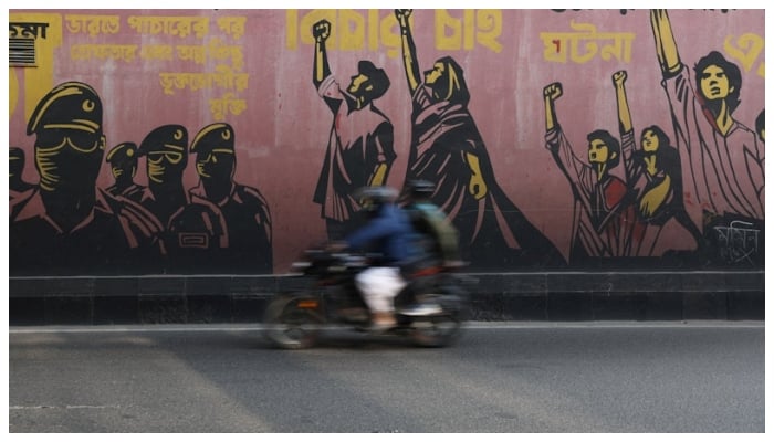 A motorcycle passes by a graffiti the morning after the election in Dhaka, February 13, 2026.—Reuters