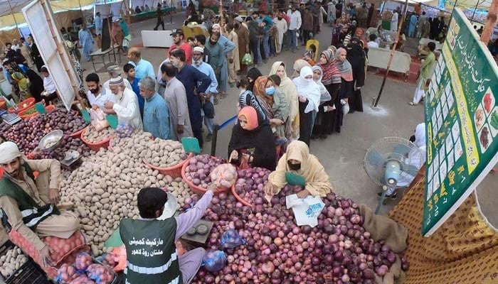 People are standing in long queues to buy vegetables from a vendor at Ramadan Sasta Bazaar in the Islampura area in Lahore on April 27, 2022. — Online/File