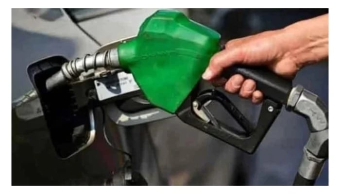 A representational image of a man holding a fuel nozzle at a petrol station. — AFP/File