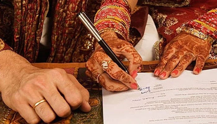 A representational image showing a bride signing Nikahs papers. — Facebook/@Nikah Halal/File