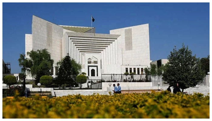 Police officers walk past the Supreme Court building in Islamabad on April 6, 2022. — Reuters