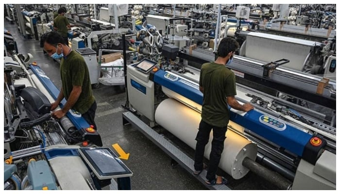 This picture shows workers operating machines at the Kohinoor Textile Mills in Lahore. — AFP/File
