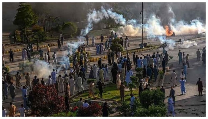 Police fire teargas shell towards Pakistan Tehreek-e-Insaf party activists and supporters of former Pakistan Prime Minister Imran to disperse them during a protest against the arrest of their leader on May 9, 2023. — AFP