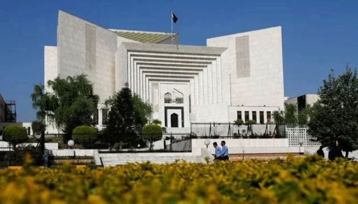 Police officers walk past the Supreme Court of Pakistan building, in Islamabad, on April 6, 2022. — Reuters