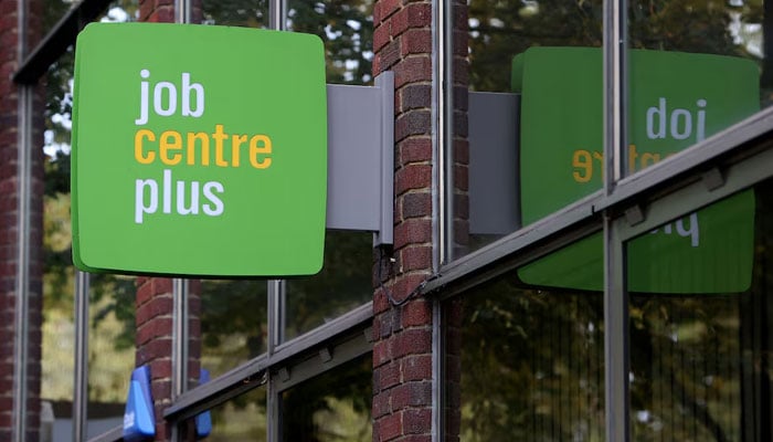 People walk alongside a Job Centre Plus in London, Britain, October 25, 2023. — Reuters