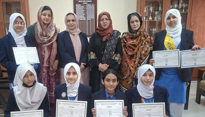 Principal Prof. Munaza Faheem poses for a photo with students at the college on February 20, 2026. — Facebook@Islamabad Model College For Girls Korang Town Islamabad