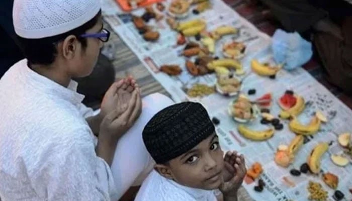 This representational  image shows two children praying at the time of breaking the fast. — AFP/File
