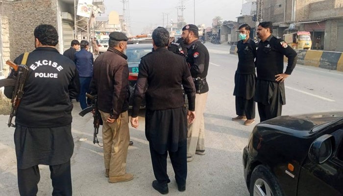 Personnel of the Excise Department KP standing on a road on February 17, 2026. — Facebook@. — Facebook@ExciseKPGovt