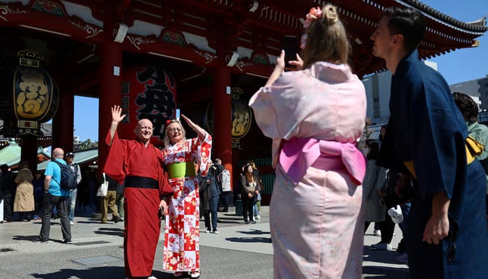 Foreign tourists wearing Japanese traditional kimono clothes pose for a photograph near Sensoji temple at Asakusa district, a popular sightseeing spot in Tokyo, Japan March 10, 2025. — Reuters