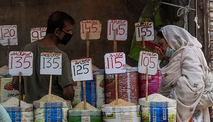 The representational image shows a woman checking the smell of rice at a market. — AFP/File