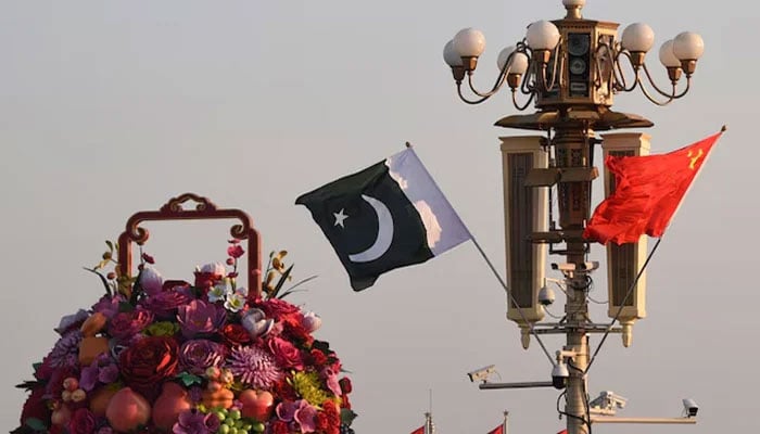 Pakistani and Chinese national flags flutter next to an installation featuring a giant flower basket at the Tiananmen Square in Beijing, China on October 7, 2019. — Reuters