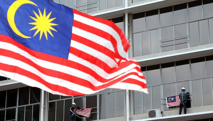 Workers hang Malaysian flags ahead of celebrations for the country’s 62nd anniversary of independence on August 31 in Kuala Lumpur, Malaysia, July 31, 2019. — Reuters