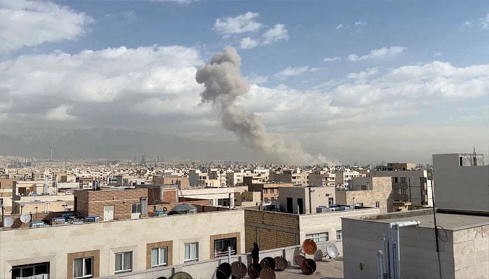A plume of smoke rises following a reported explosion in Tehran on February 28, 2026. — Reuters