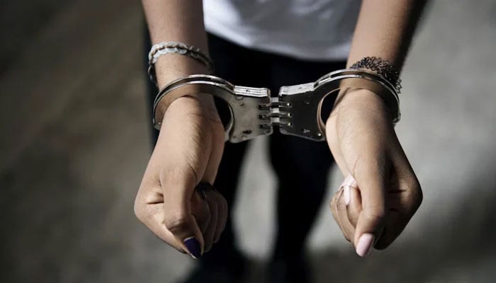 A representational photo of a woman in handcuffs. — Unsplash/File