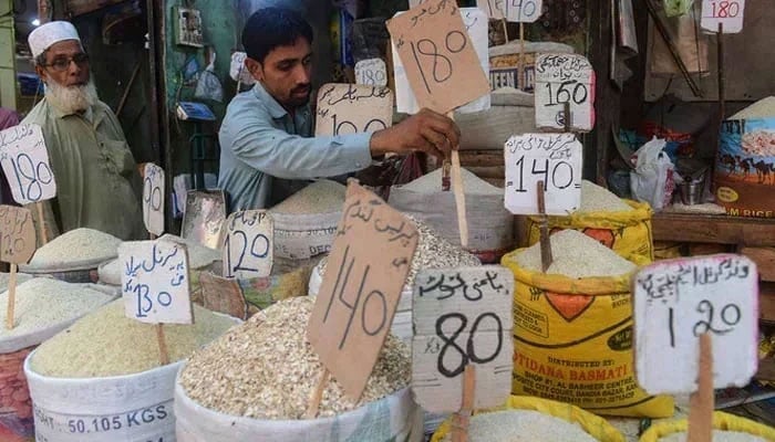 The representational image shows a shopkeeper placing a price tag on rice at a shop. — AFP/File