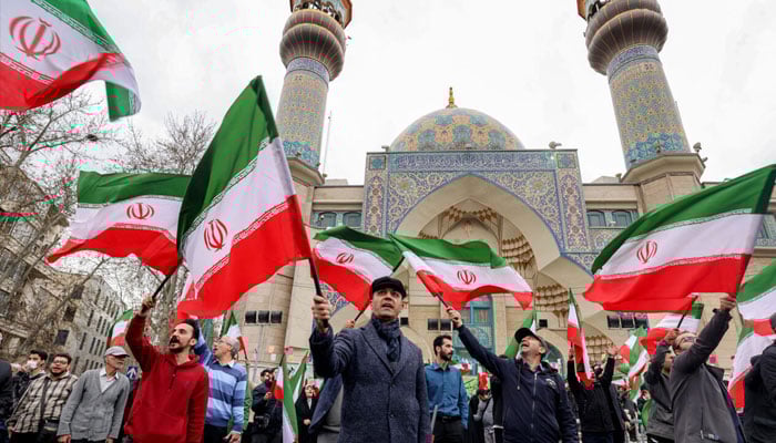 Pro-government protestors waved national flags during a demonstration in support of the government, but US and Israeli strikes and a strong security presence drove many Iranians to seek shelter. — AFP/File