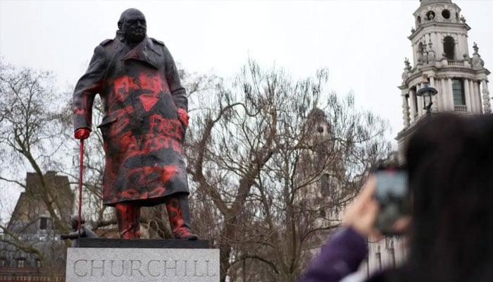 Graffiti, including Never again is Now and Free Palestine, appeared on the statue of the former prime minister. —Reuters