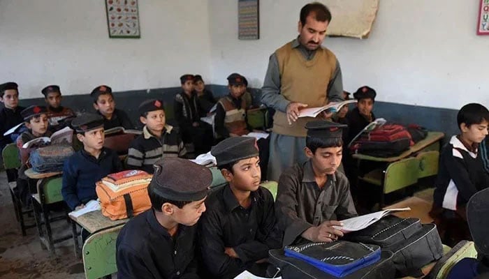 Children attend a class at a school in KP. — AFP/File