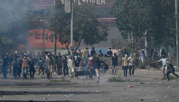 People throw stones at riot police during a protest outside the US consulate in Karachi on March 1, 2026. — AFP