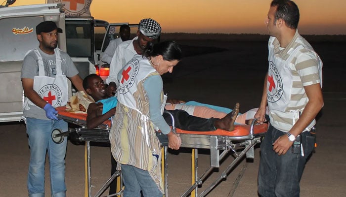 Red Cross workers offloading a patient from an ambulance. —icrc.org/File