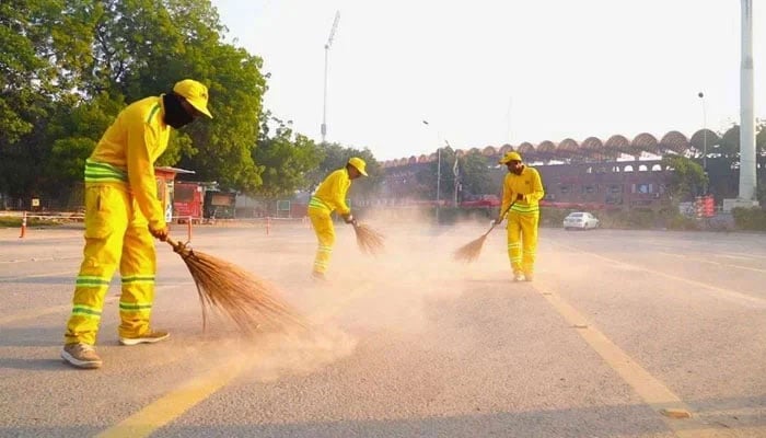 The representational image shows the Lahore Waste Management Company (LWMC) workers cleaning the streets. — APP/File