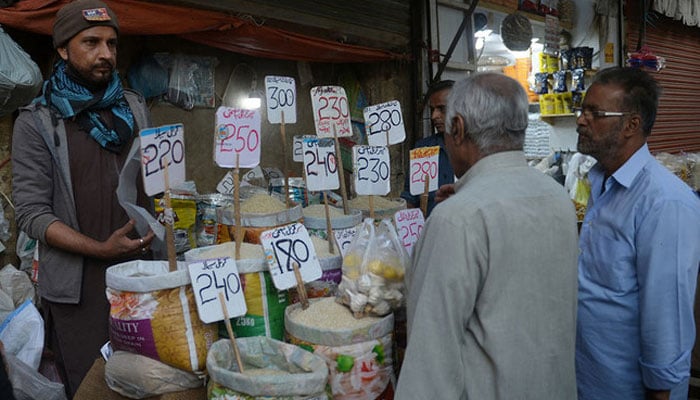 People buy rice at a wholesale market in Karachi on February 1, 2023. — AFP