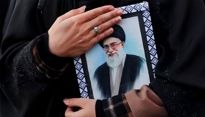 A woman holds on to a picture of Irans Supreme Leader Ayatollah Ali Khamenei at the Enghelab Square, after he was killed in Israeli and US strikes on Saturday, in Tehran, Iran, March 1, 2026.—Reuters