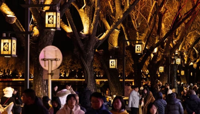 People walk on the illuminated bank of Qianhai lake in the historical Shichahai district, ahead of Lunar New Year celebrations welcoming the Year of the Fire Horse, in Beijing, China, February 15, 2026.—Reuters