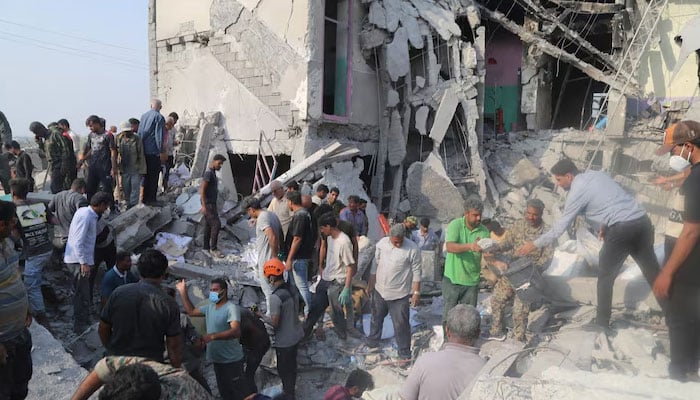 People and rescue forces work following a strike on a school in Minab, Iran, February 28, 2026. — Reuters