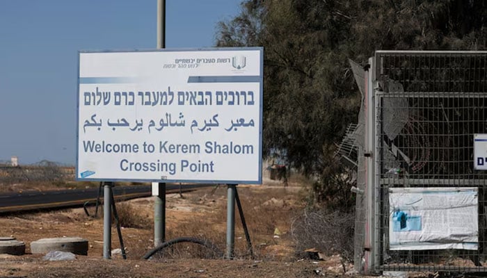 A view shows a sign as trucks carrying aid (not pictured) wait at the Israeli side of the Kerem Shalom border crossing to southern Gaza in southern Israel, October 20, 2025. —Reuters