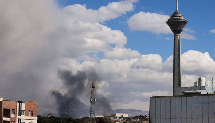 A plume of smoke rises following reported explosions in Tehran on March 1, 2026. — AFP