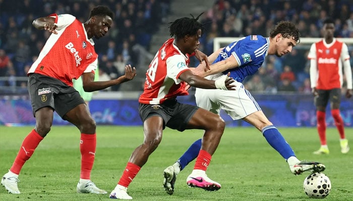 Reims Ivorian defender Elie Tamon (centre) fights for the ball with Strasbourg s Argentine forward Joaquin Panichelli during the French Cup quarter final football match between RC Strasbourg Alsace and Stade de Reims at the Stade de la Meinau in Strasbourg, eastern France. —AFP