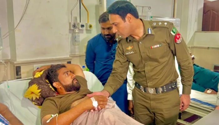 An official of the Punjab police inquires about the health of a police personnel at a hospital on October 18, 2025. — Instagram@digopslahore