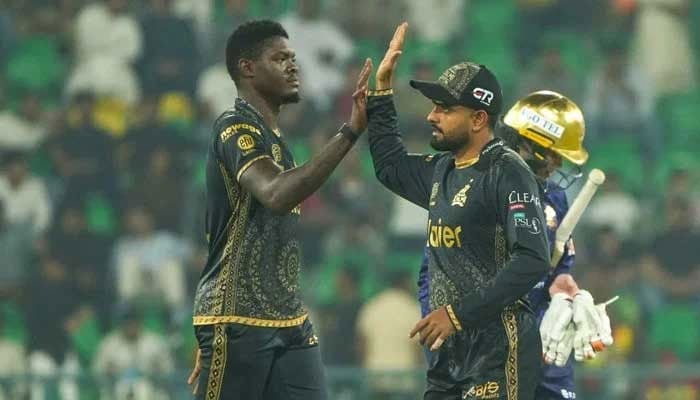 Peshawar Zalmis Alzarri Joseph (left) celebrates taking a wicket with teammate Babar Azam during their PSL match against Quetta Gladiators at the Gaddafi Stadium in Lahore on April 27, 2025. — PSL