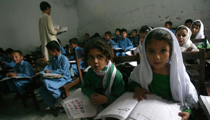 Female students Shaista (right), 12, and Rabia (left), 10, read aloud while taking part in class in Buner district about 220 km (137 miles) by road from Pakistans capital Islamabad on August 10, 2009. — Reuters