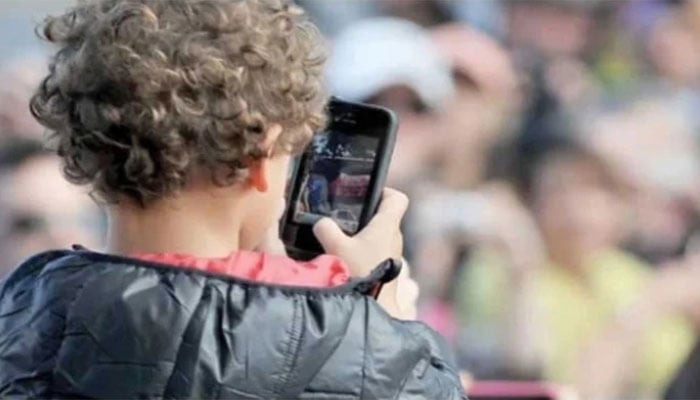 This photo taken on April 20, 2013 shows a child using a smartphone at Caulfield Racetrack in Melbourne. — AFP/File