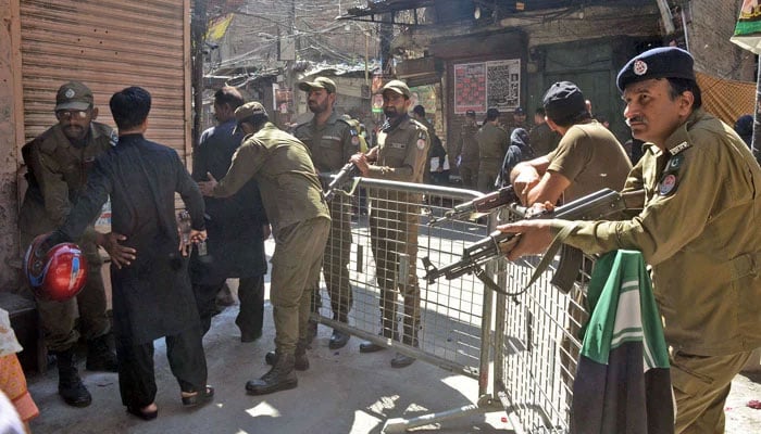 Police personnel stand alert during the mourning procession in connection with Youm-e-Ali (R.A) in Lahore on March April 1, 2024. — Online