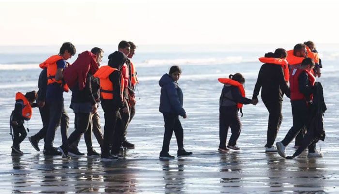 Migrants walk away from the beach after a failed attempt to cross the English Channel to reach Britain, from Petit-Fort-Philippe beach in Gravelines, near Calais, France, September 27, 2025. — AFP
