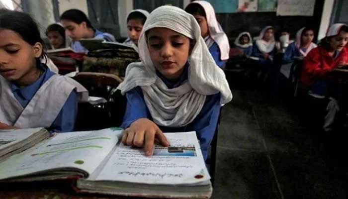 A girl reads a book while attending her daily class with others at a government school. — Reuters/File